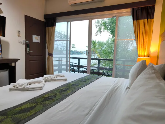 Deluxe Skyline River Corner room with king bed, sitting area, and corner river view — Gallery image 1