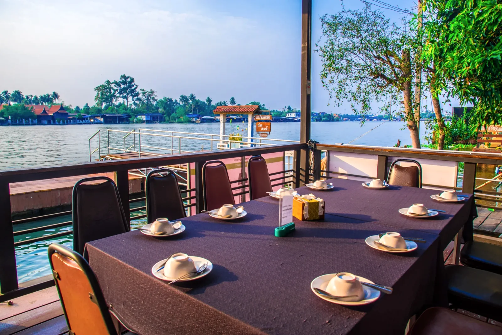 Tables set with cups on Baantip's river terrace
