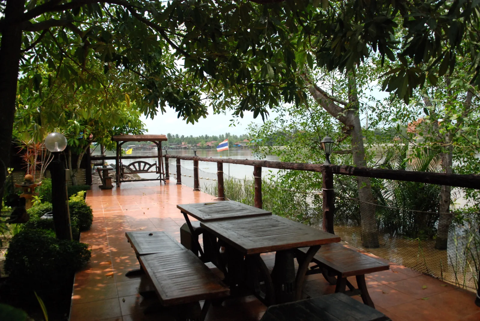 Wooden table and benches beside the river at Baantip